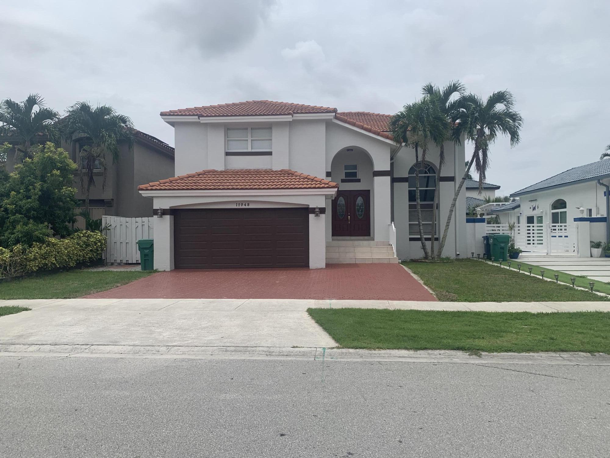 a front view of a house with a garden and garage