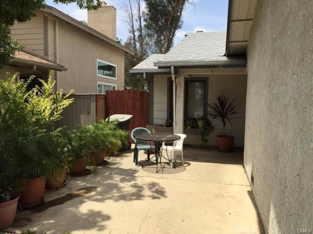 a view of a chair and table in backyard of the house