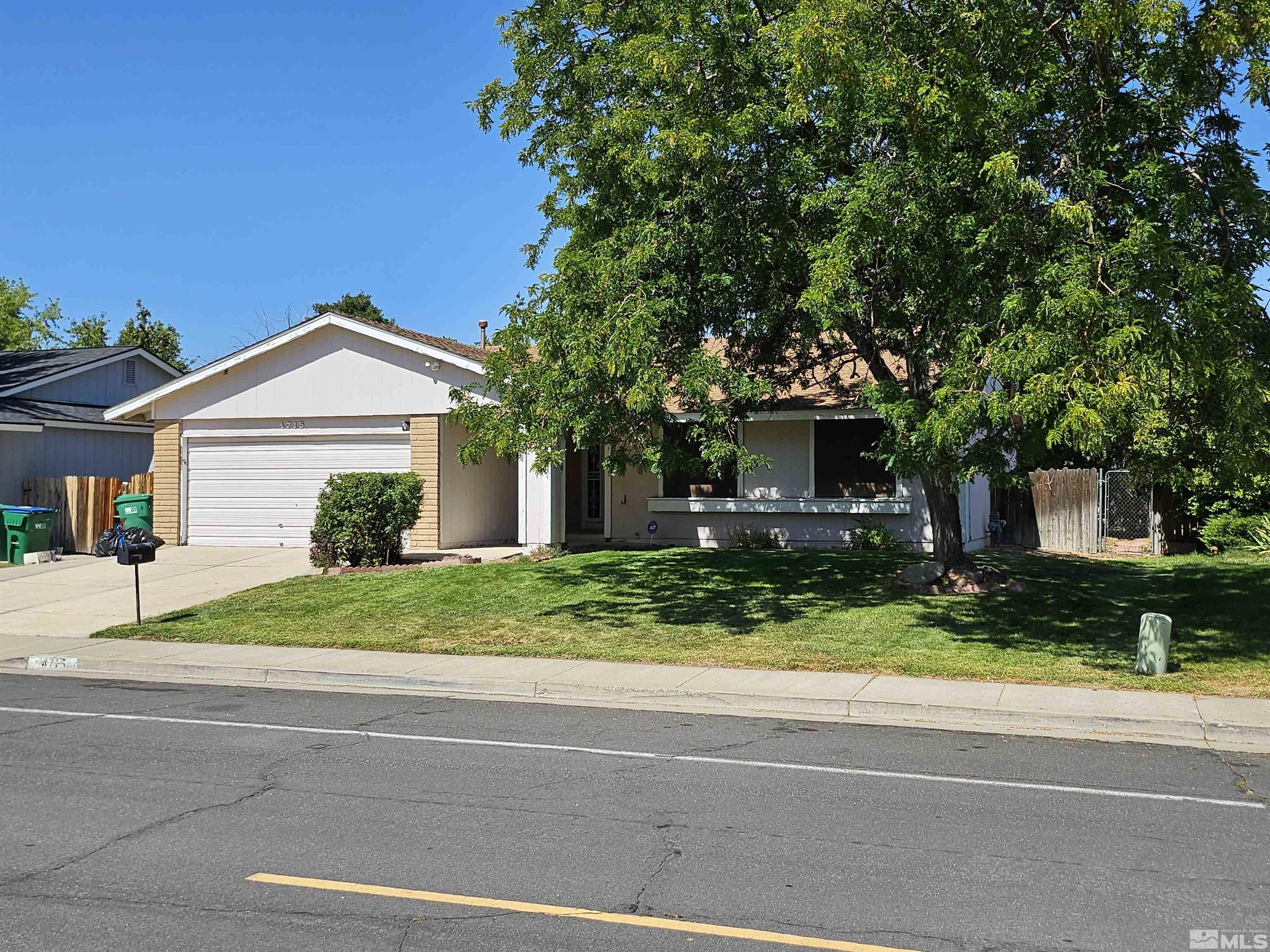 a front view of a house with a yard and potted plants