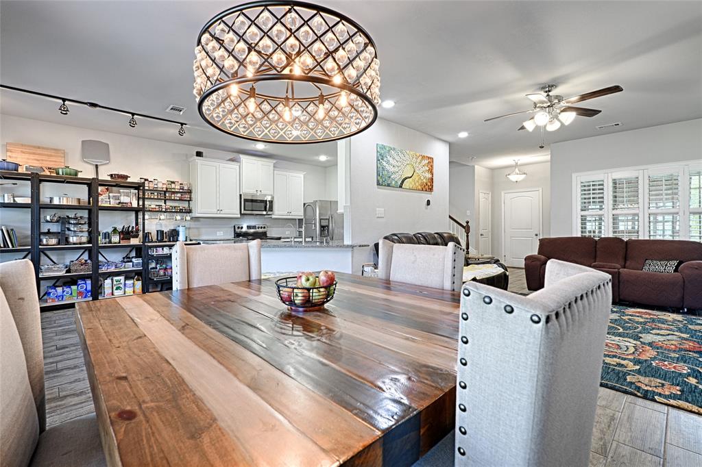 a view of a dining room with furniture a chandelier and wooden floor