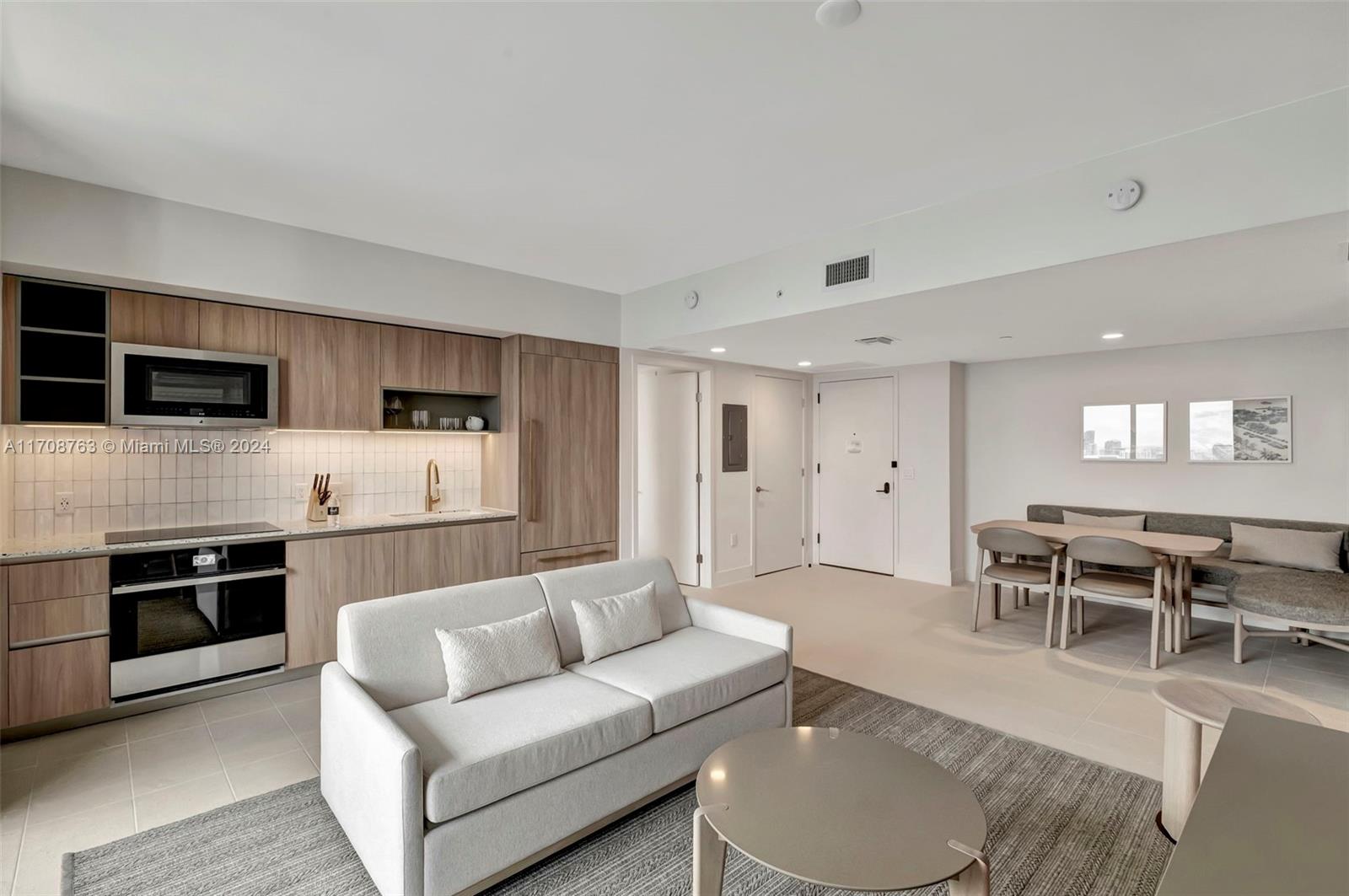 a living room with furniture a dining table and kitchen view