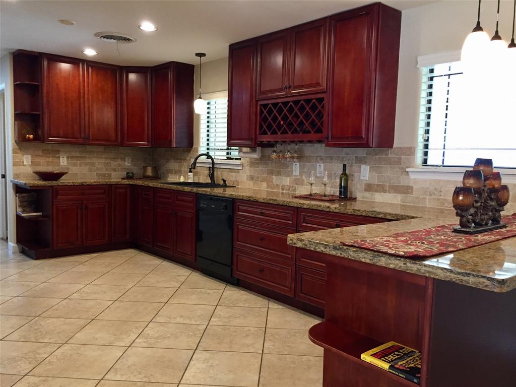 a kitchen with stainless steel appliances granite countertop wooden cabinets a stove top oven a sink and dishwasher