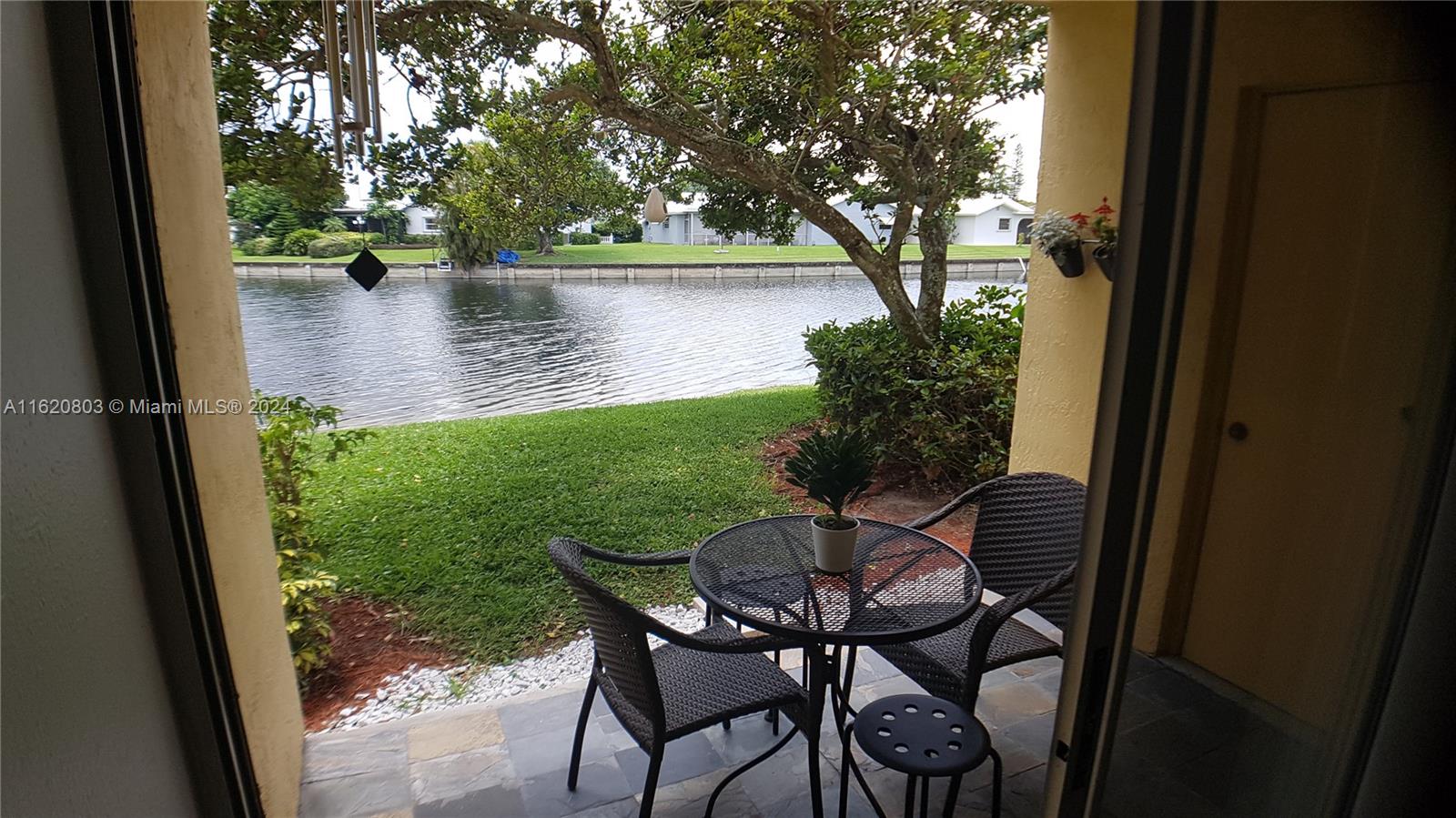 a view of a chairs and table in patio with a yard