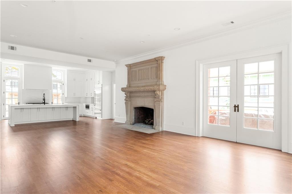 a view of a livingroom with wooden floor and a fireplace