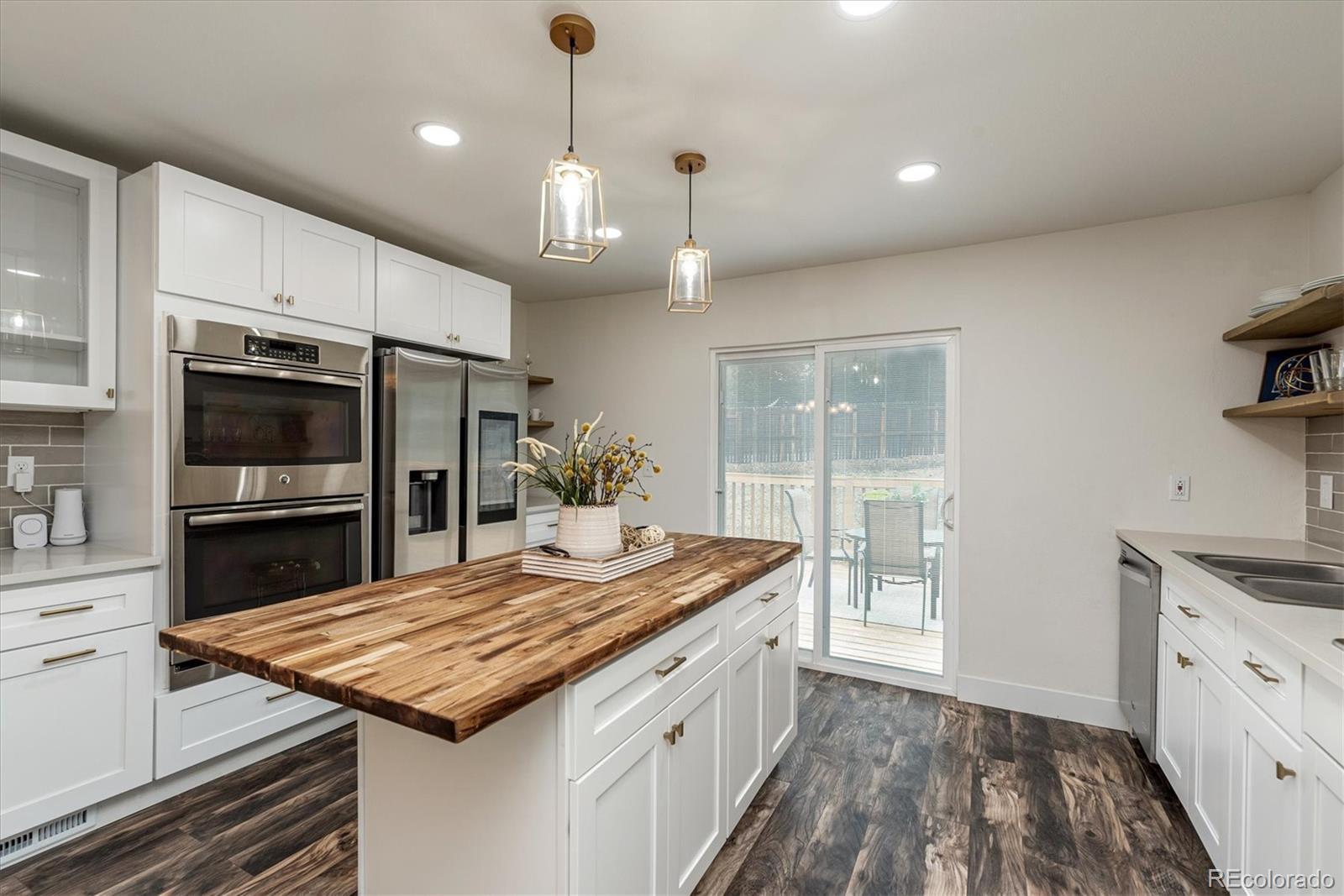 a kitchen with kitchen island granite countertop a sink and stainless steel appliances