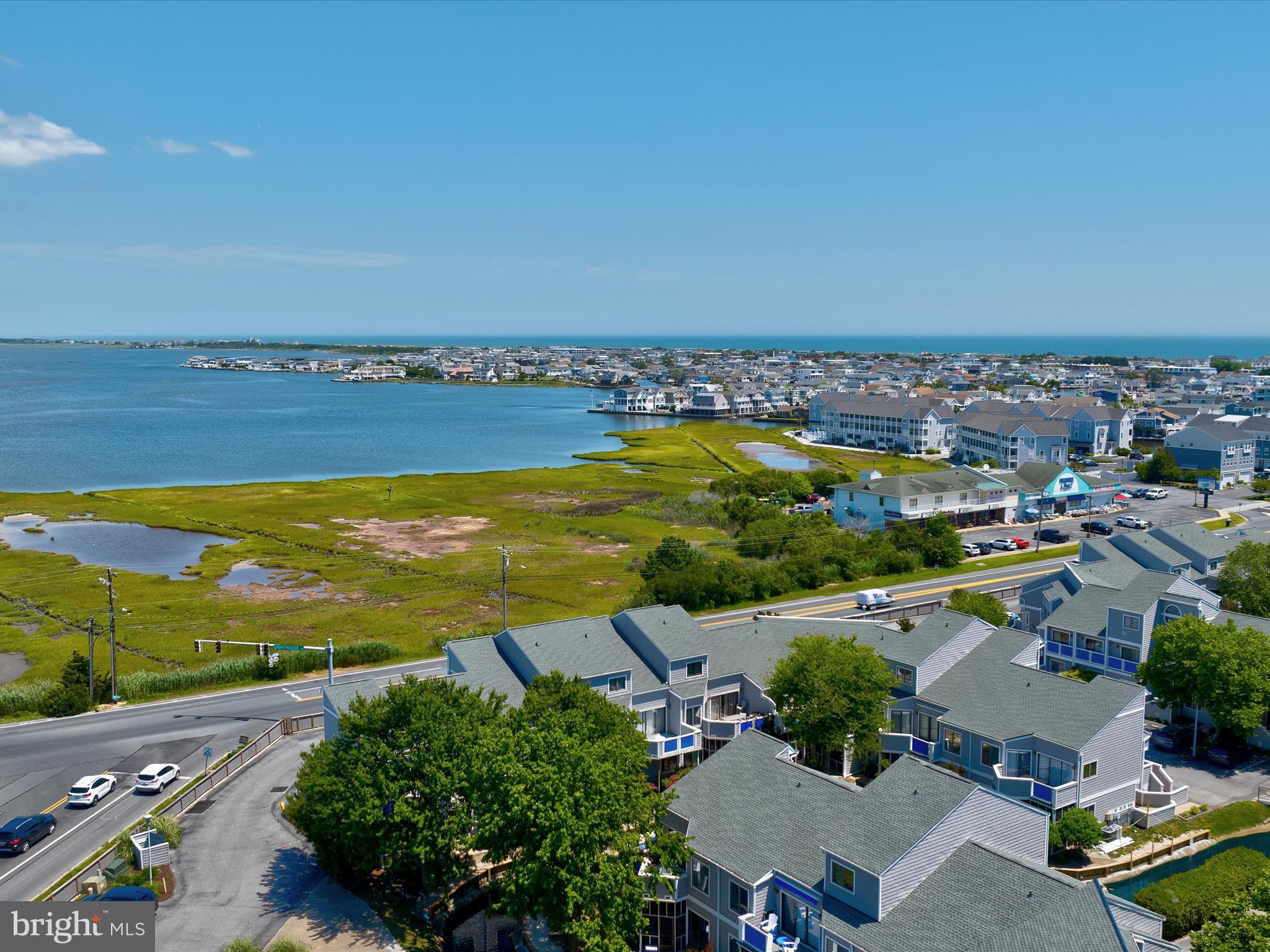 an aerial view of ocean and residential houses with outdoor space