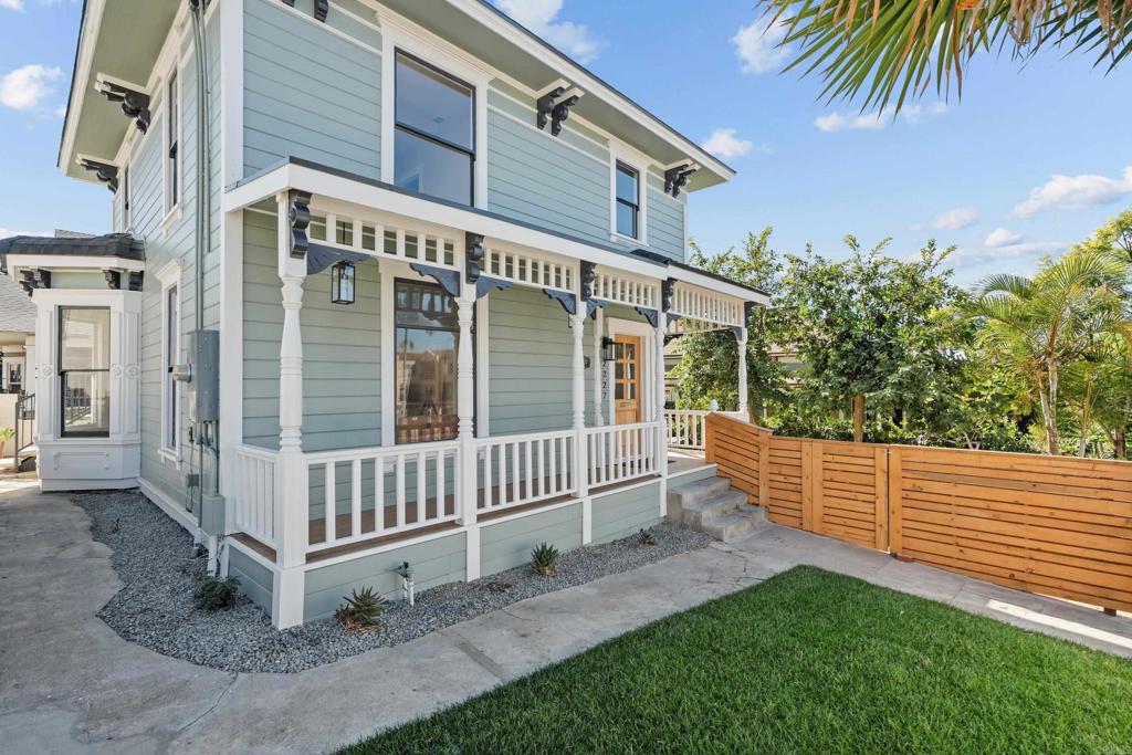 a view of a house with a yard and wooden fence