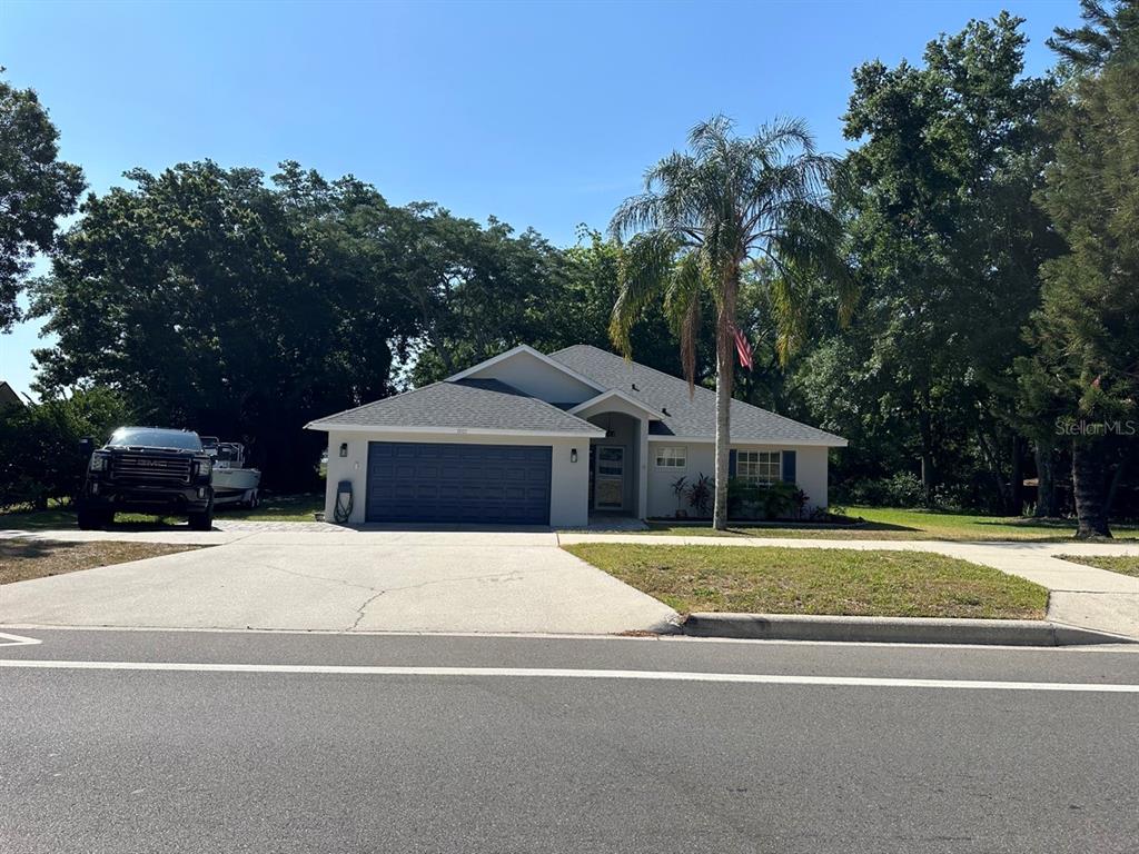 a front view of a house with a yard and trees