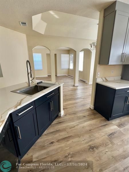 a kitchen with granite countertop a sink and a stove top oven