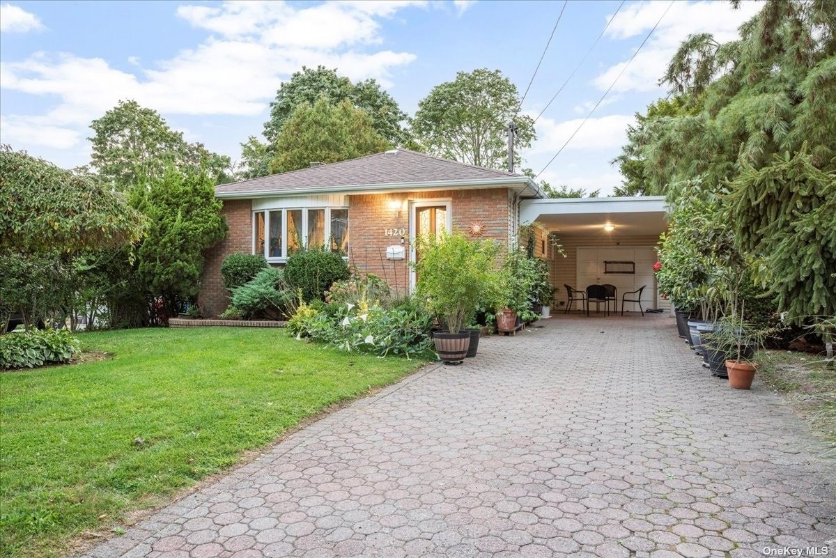 a view of a house with garden and a tree