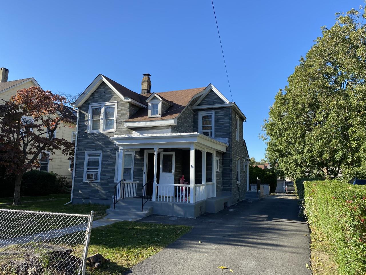 a front view of a house with a garden