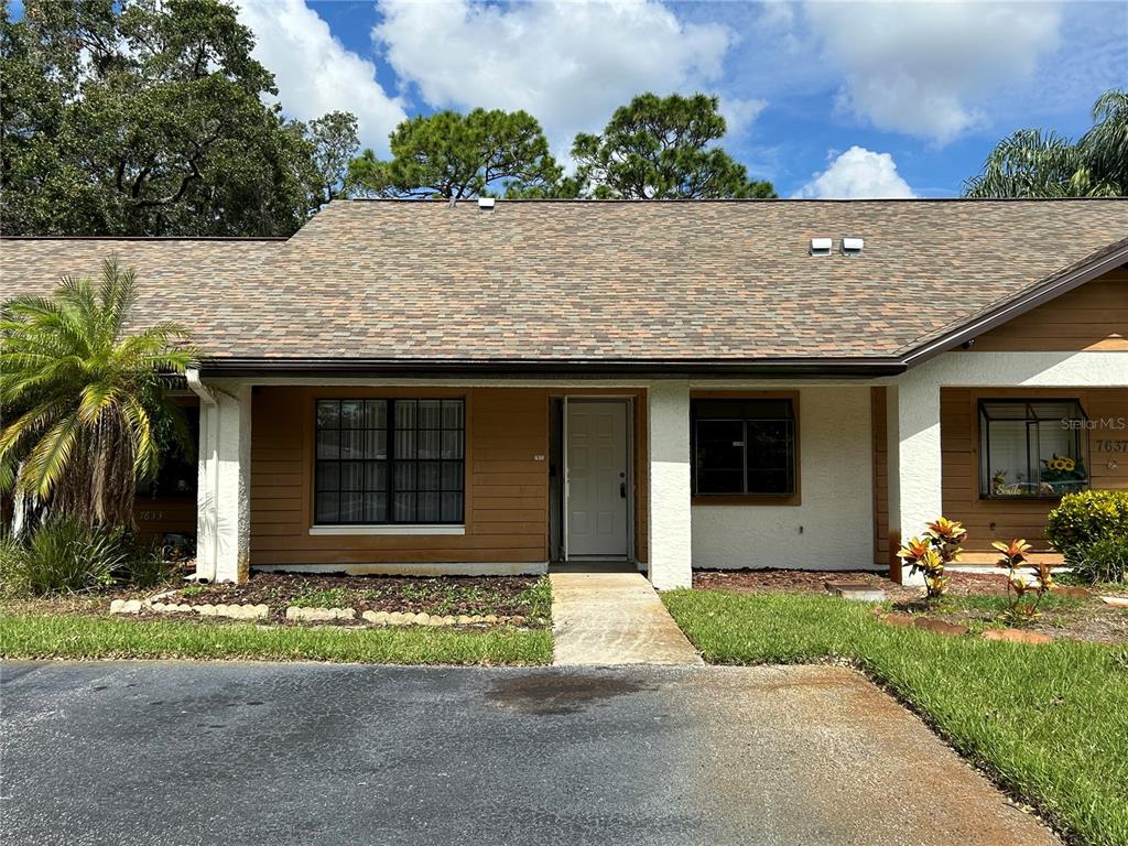 a front view of a house with a garden and plants