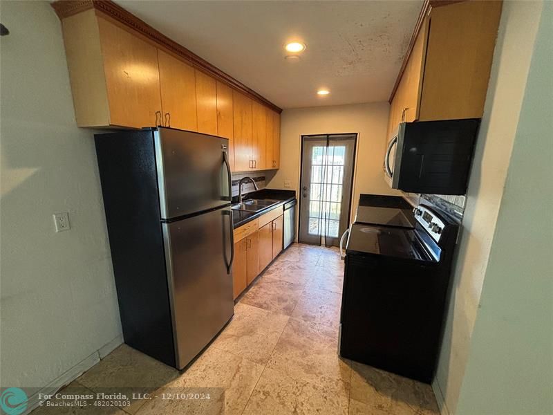 a kitchen with stainless steel appliances granite countertop a refrigerator and a microwave