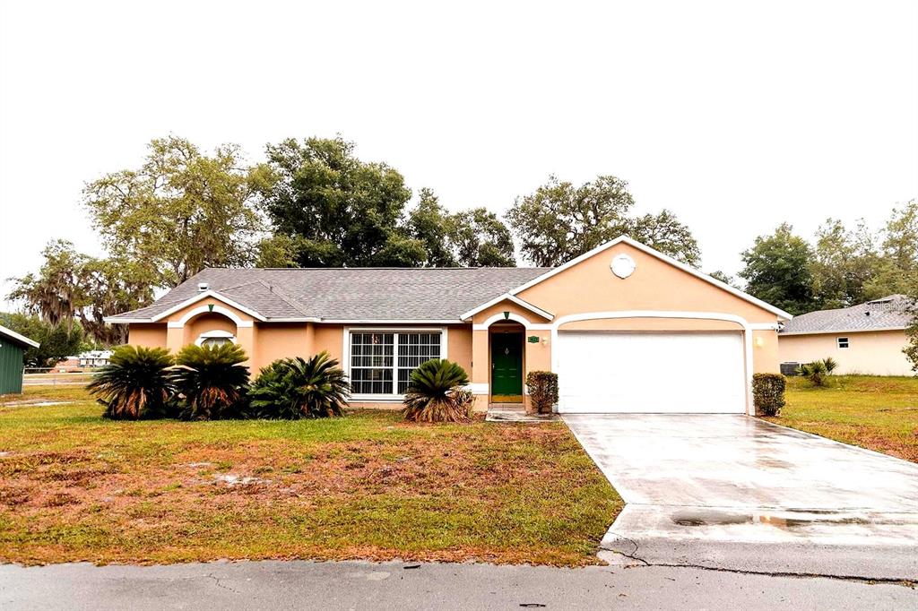 a front view of a house with a yard and trees