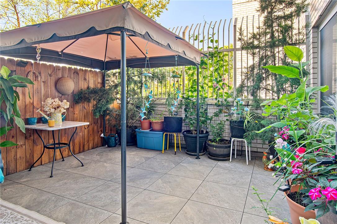 a view of a tables and chairs under an umbrella in backyard