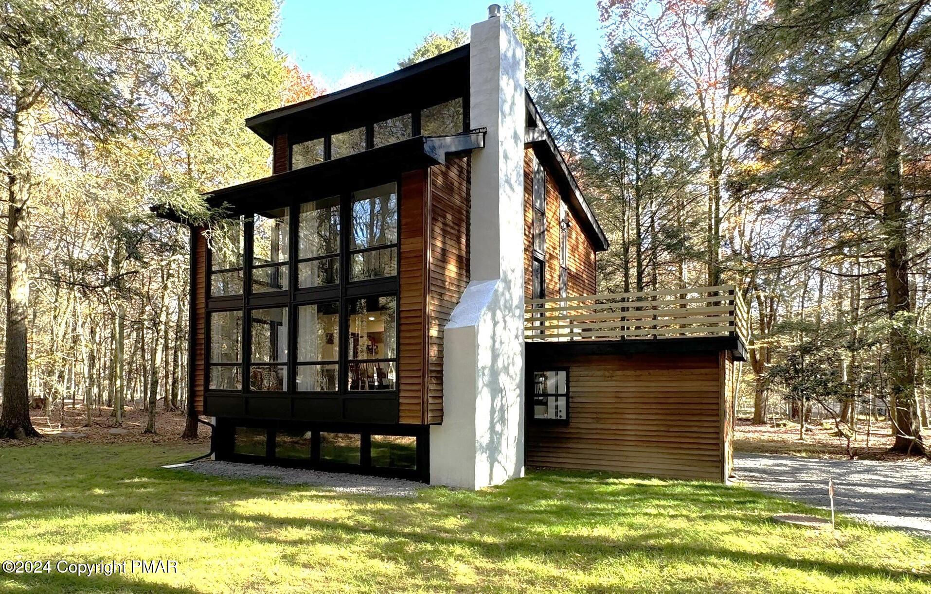 a view of a house with a yard balcony and a large tree