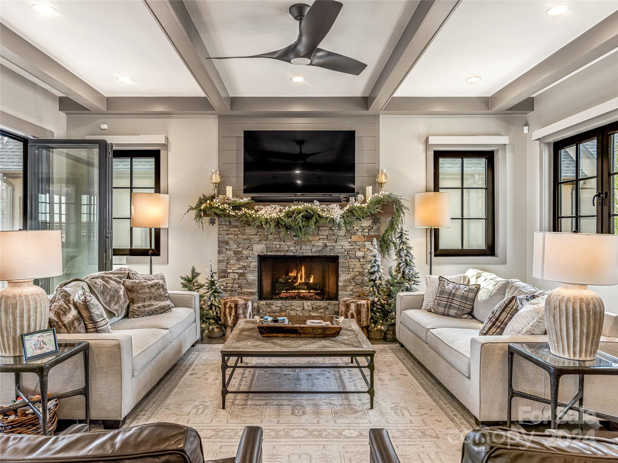 a living room with furniture a flat screen tv and a fireplace