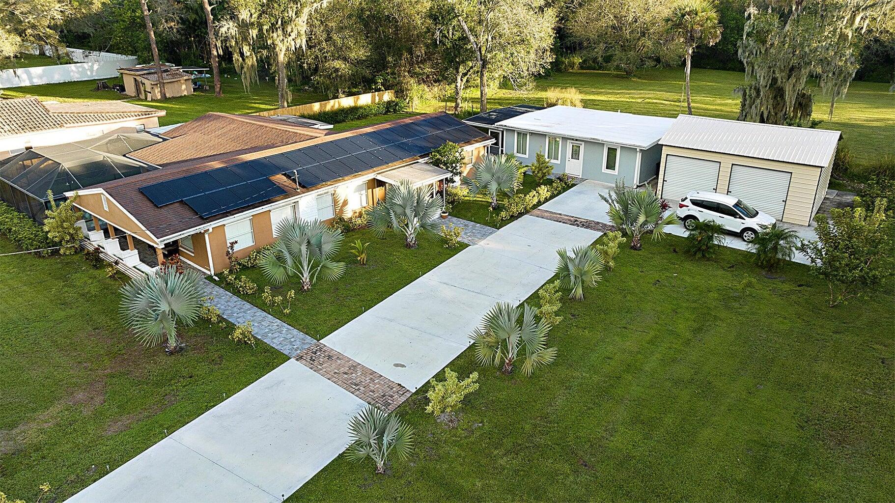 an aerial view of a house with swimming pool garden and patio