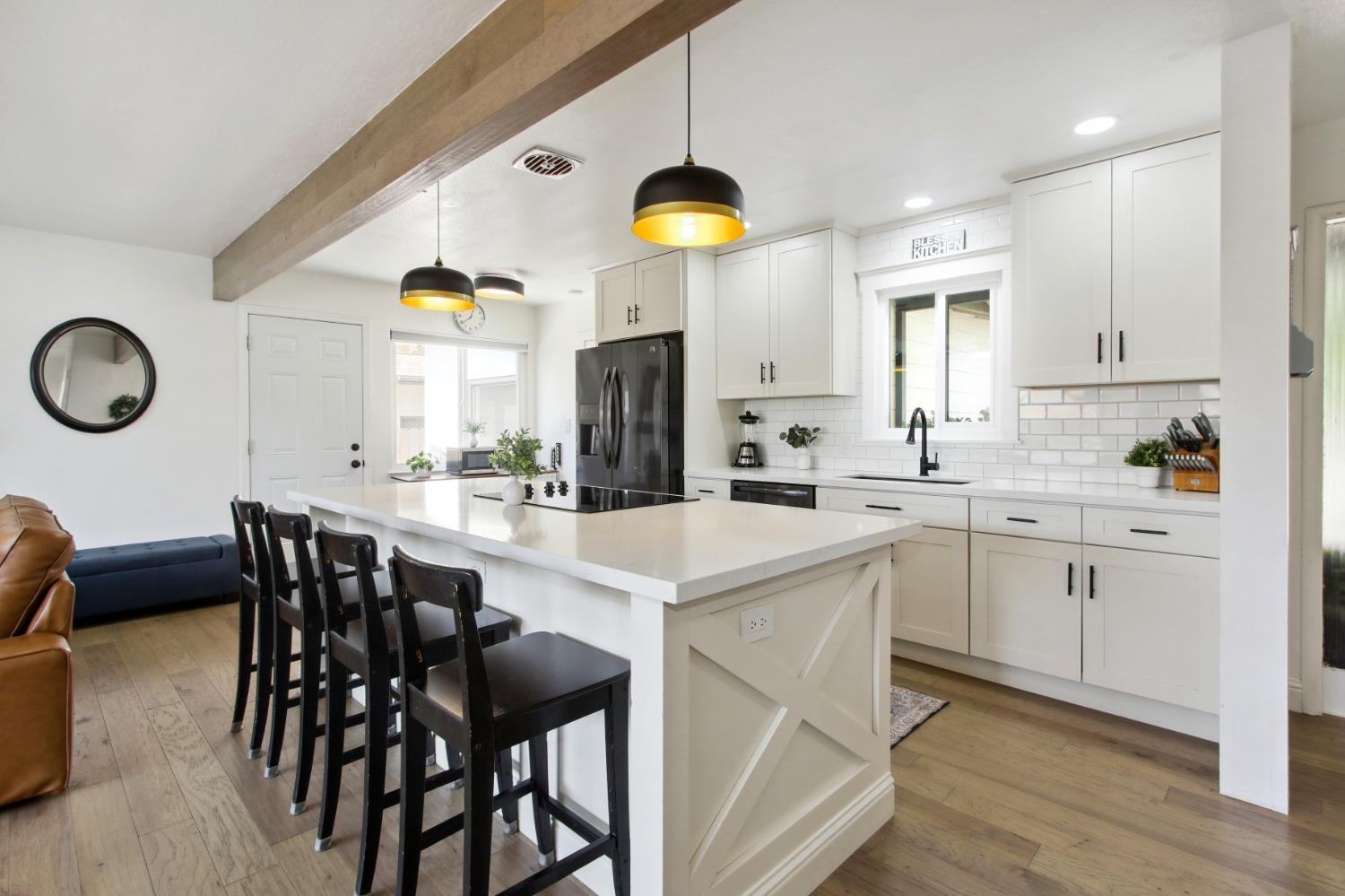 a kitchen with a dining table chairs sink and cabinets