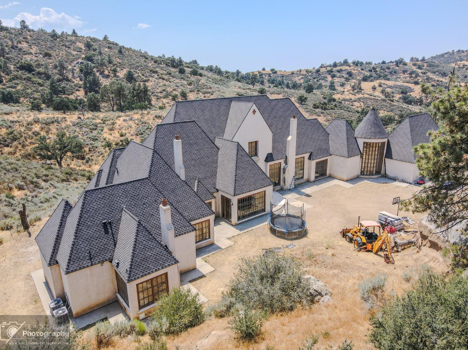 an aerial view of a house with yard and mountain view in back