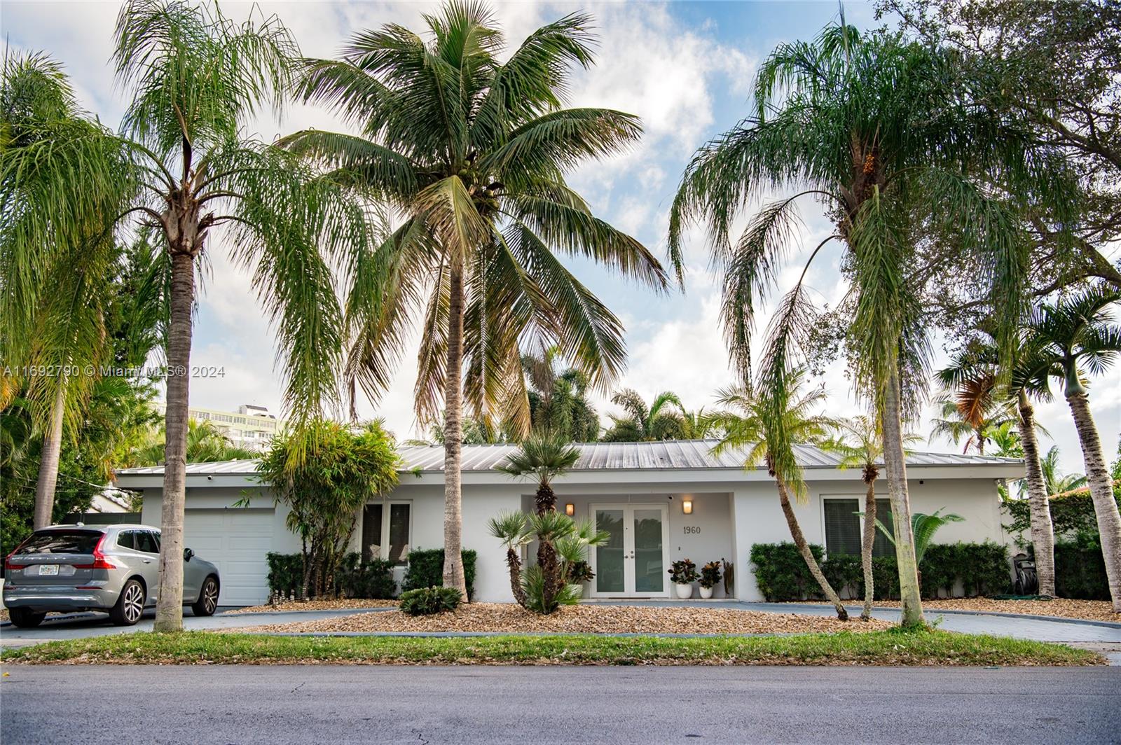 a front view of a house with a garden and plants