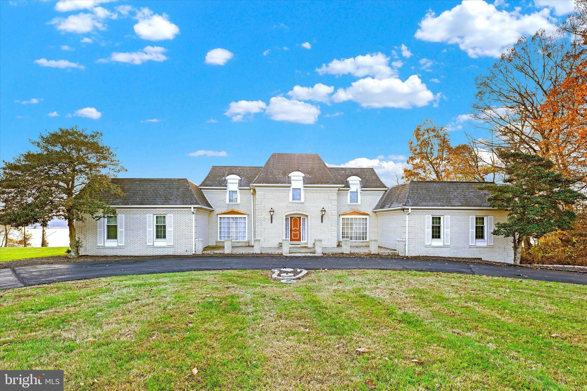 a front view of a house with a yard and trees