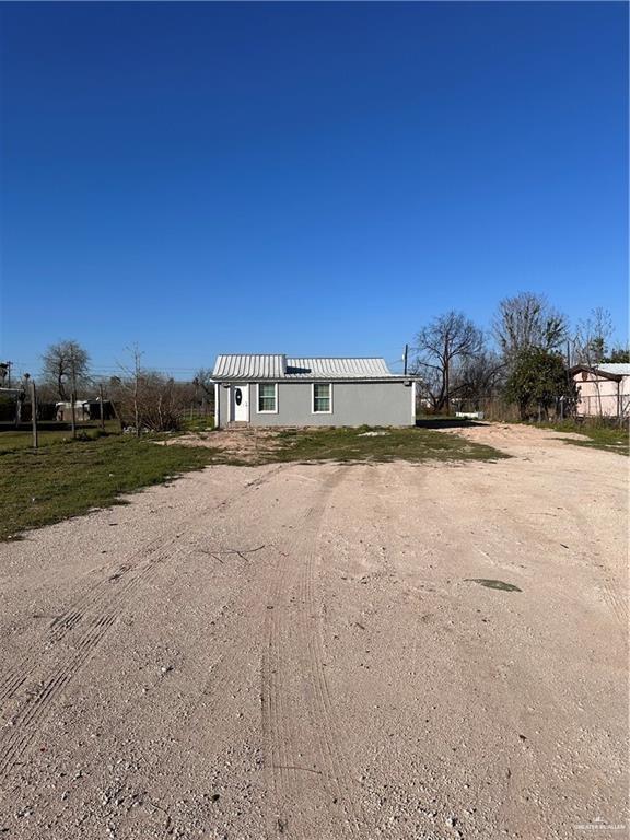 a view of dirt road with a building in the background