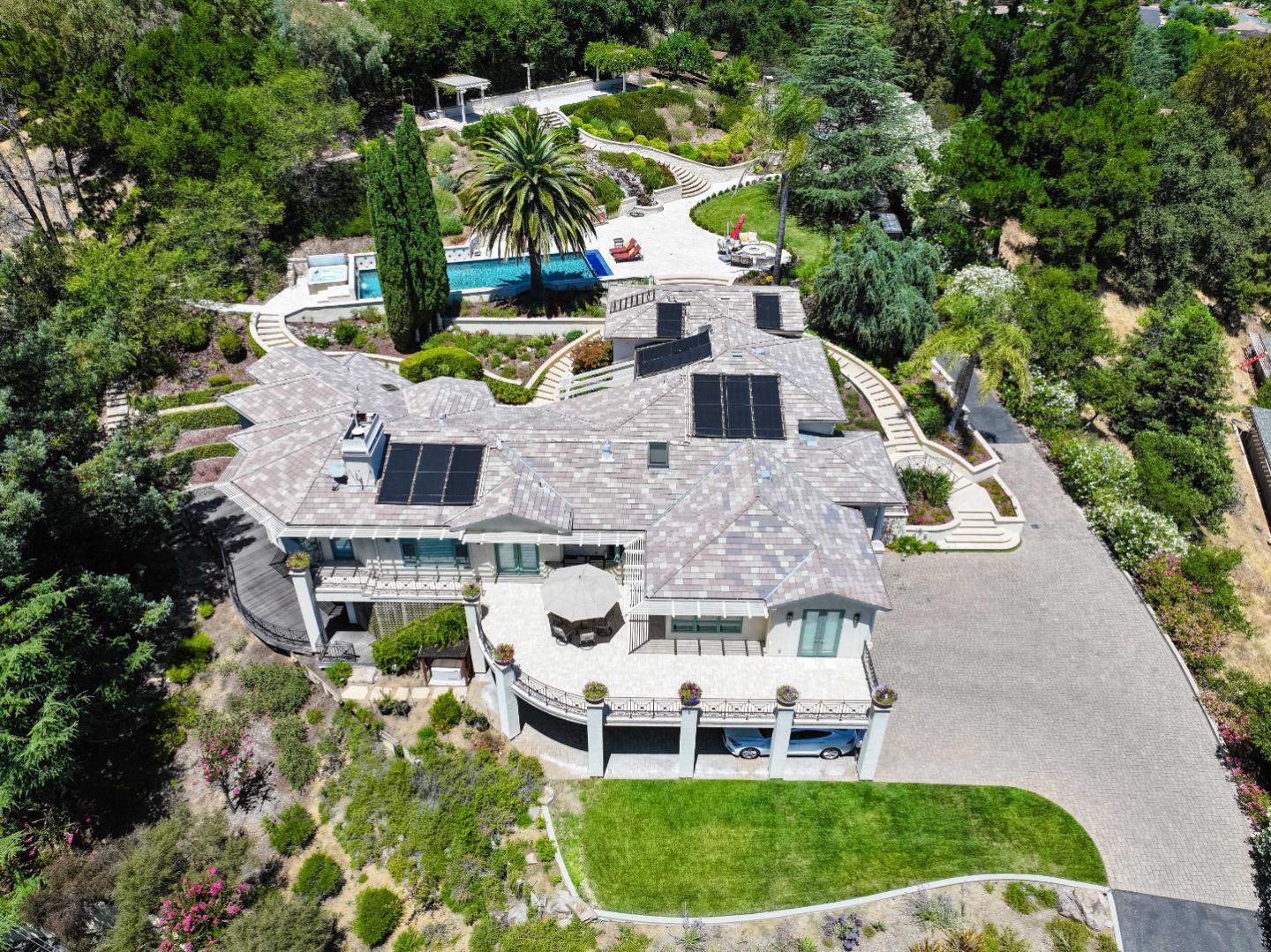 an aerial view of a house with a garden and lake view