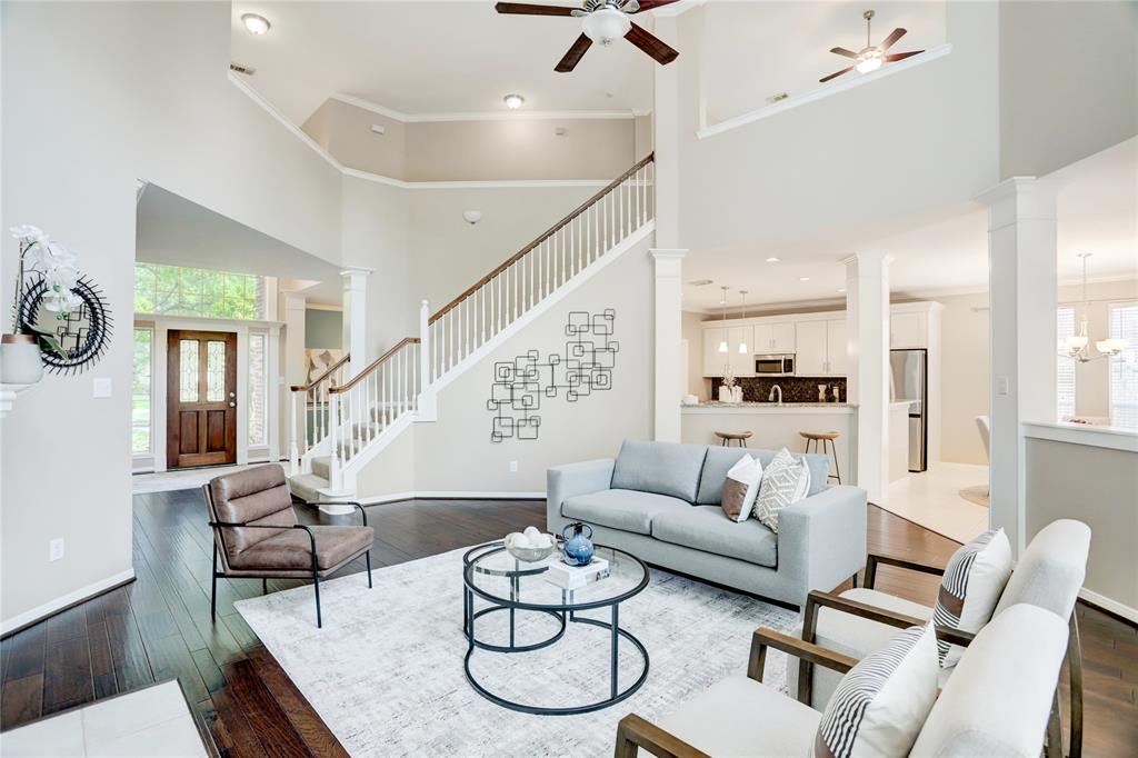 a living room with furniture kitchen view and a chandelier