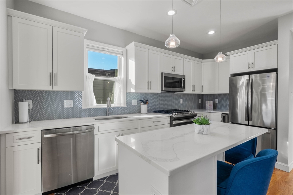 a kitchen with white cabinets stainless steel appliances and sink