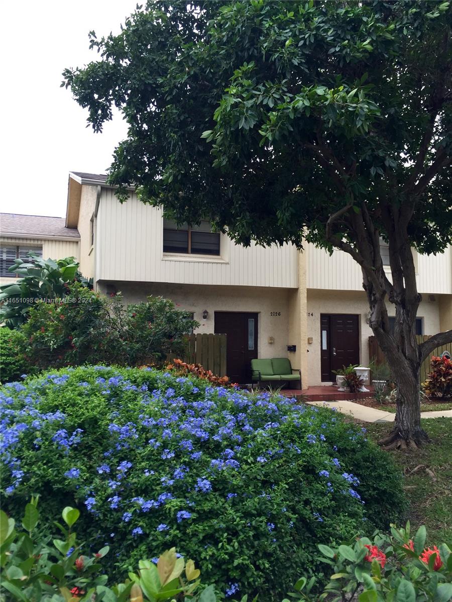 a front view of a house with a yard and trees