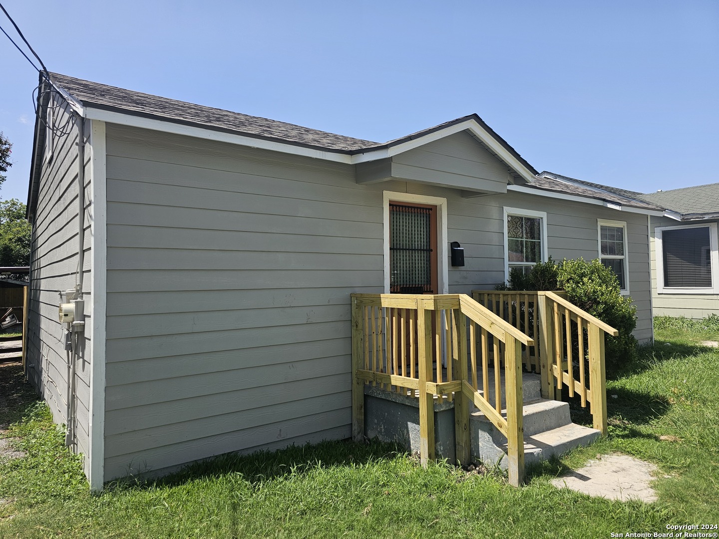 a view of a house with a small yard and wooden fence