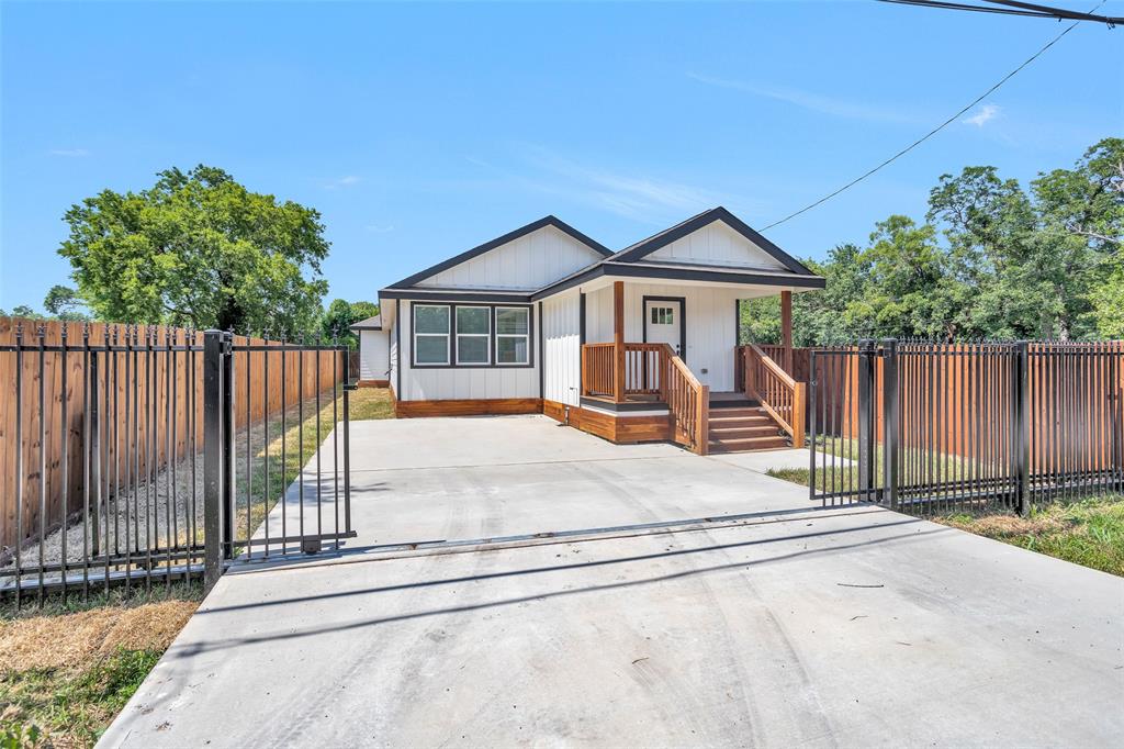 a view of a house with wooden fence next to a road