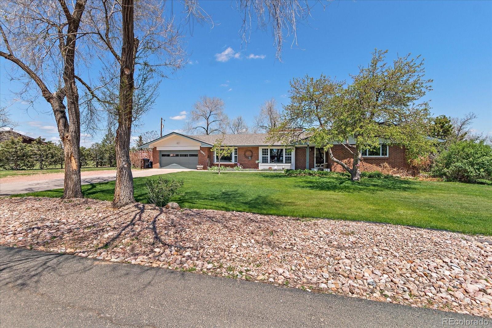 a view of a house with a big yard and large tree