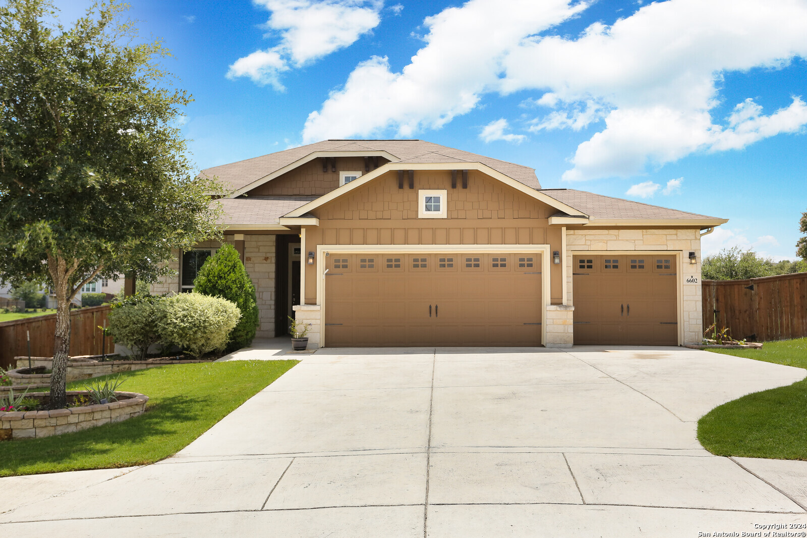 a front view of a house with a garden and garage