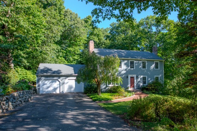 a view of a house with a yard and large tree