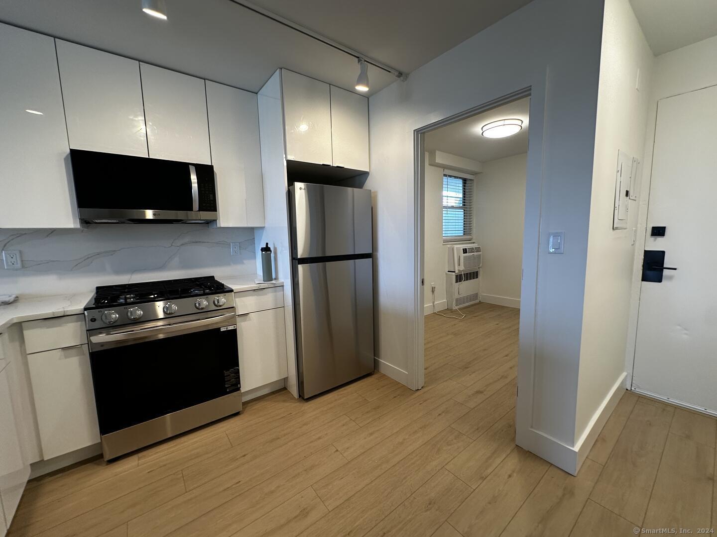 a kitchen with a refrigerator and a stove top oven