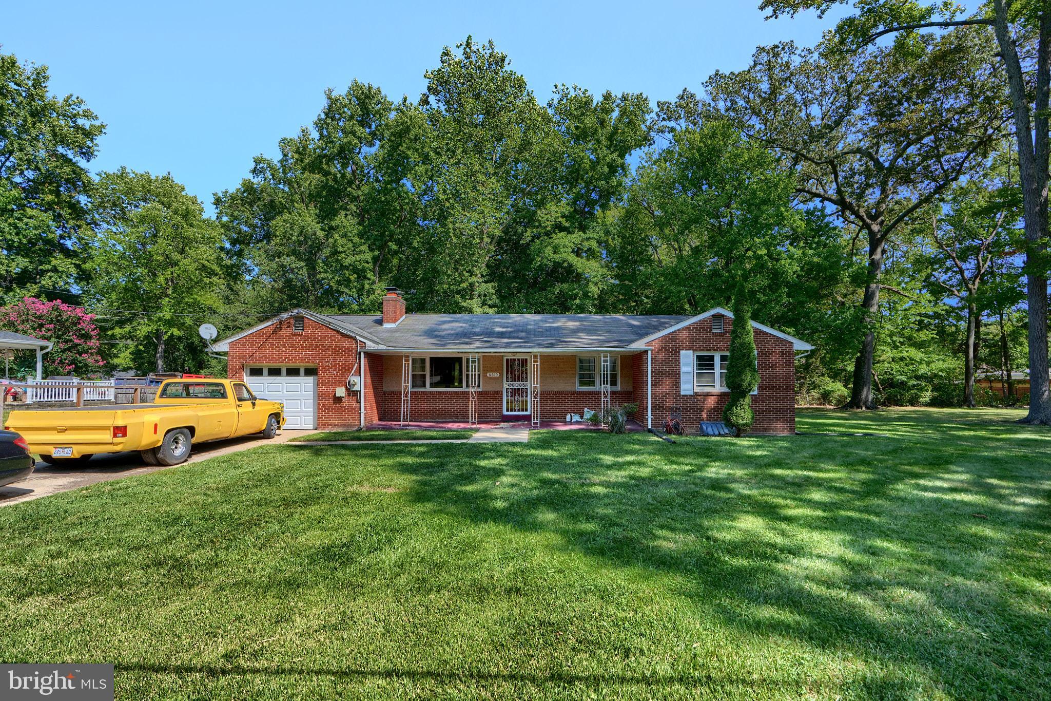 a front view of a house with yard and green space