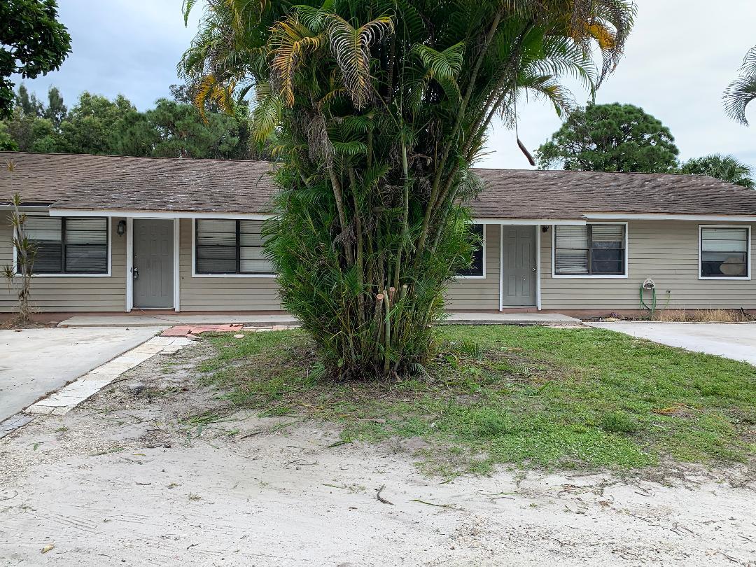 a front view of house with yard and trees around