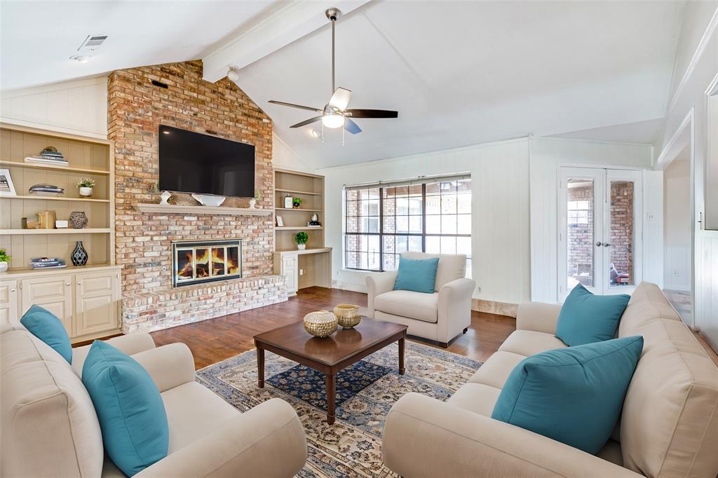 a living room with furniture a flat screen tv and a fireplace