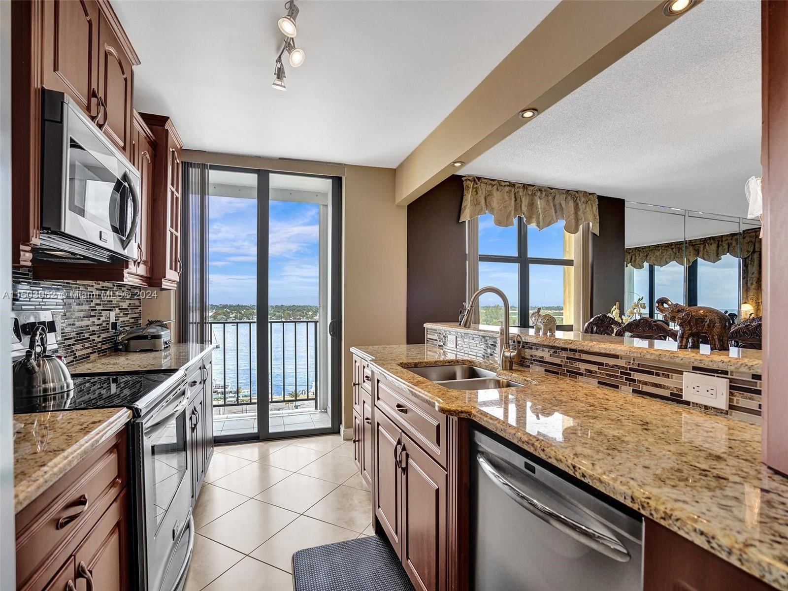 a kitchen with stainless steel appliances granite countertop a sink stove and cabinets