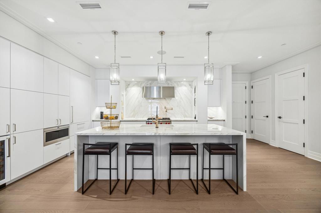 a kitchen with granite countertop a table chairs stove and cabinets