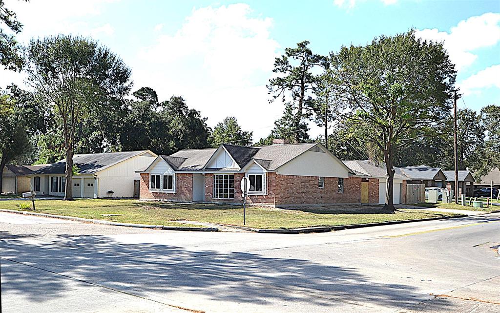 a view of a house with a big yard and large trees