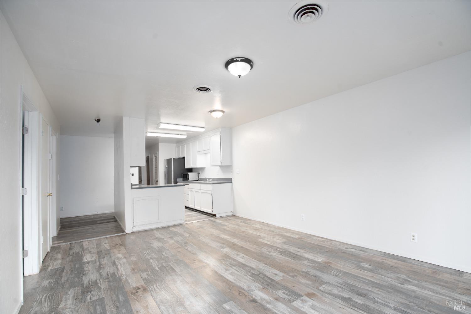 a view of a kitchen with wooden floor and a sink