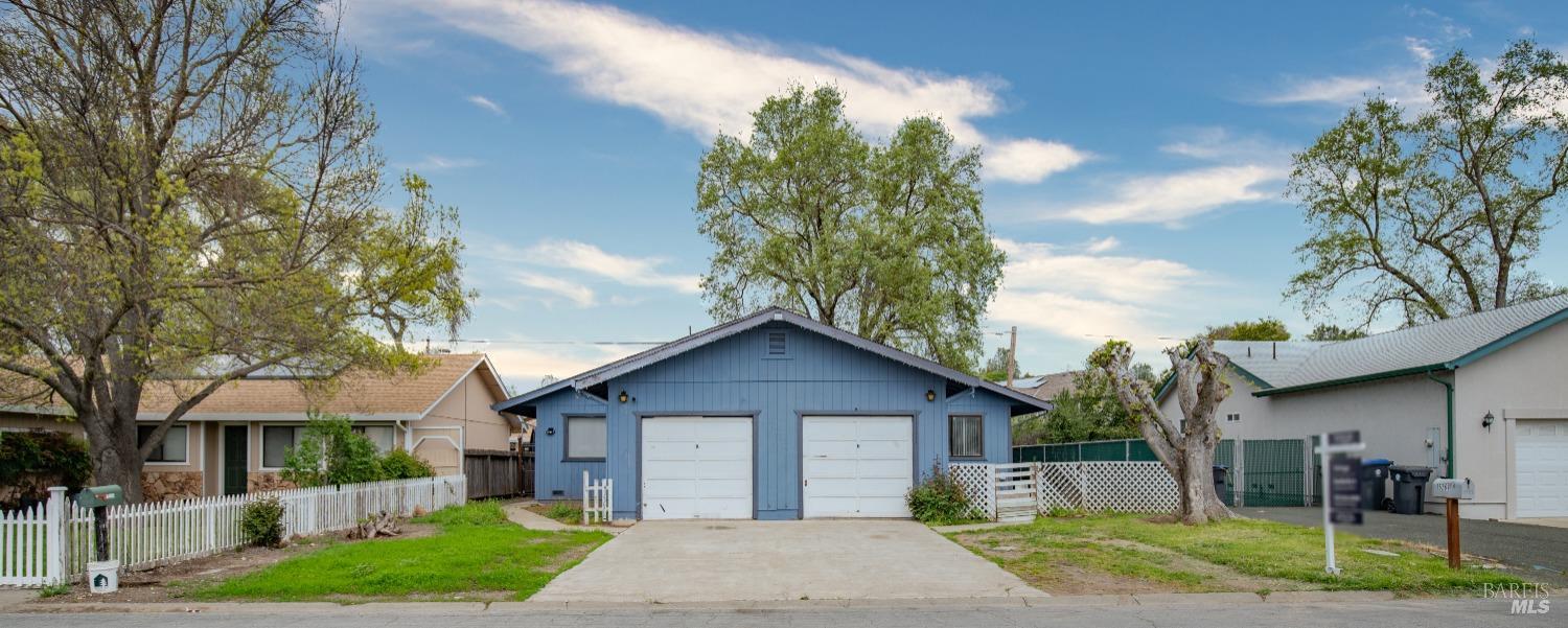 a view of a house with a yard and tree s