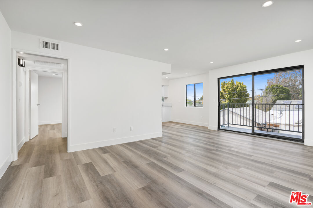 a view of a big room with wooden floor and windows