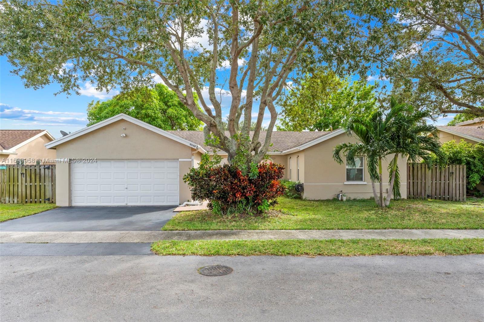 a view of a house with a yard and large tree