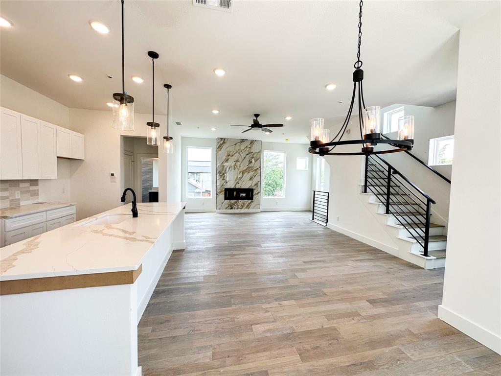 a large kitchen with kitchen island a stove a sink a refrigerator and a view of living room