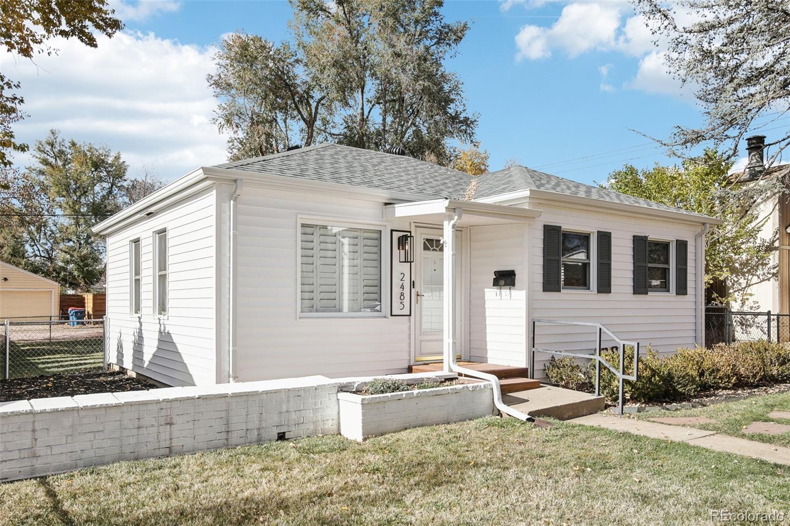 a front view of a house with a yard and seating space