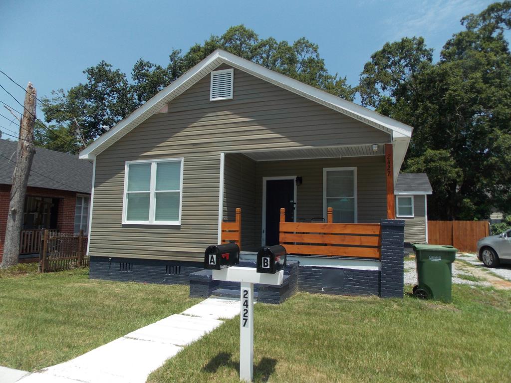 a front view of house with a garden